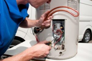 A hot water electrician installing a new element in a house in Wollongong